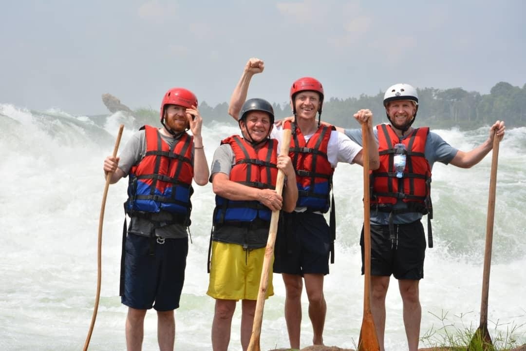 four men standing next to water