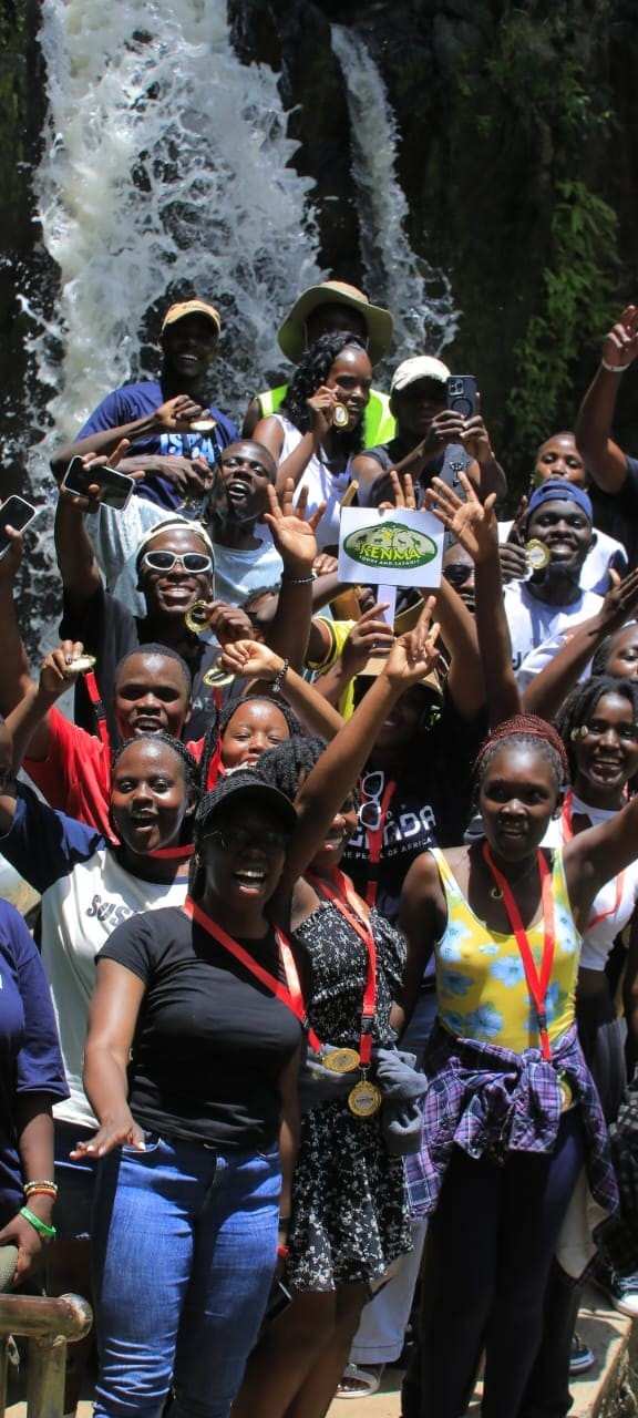 people possing for a pic holding kenmatours poster