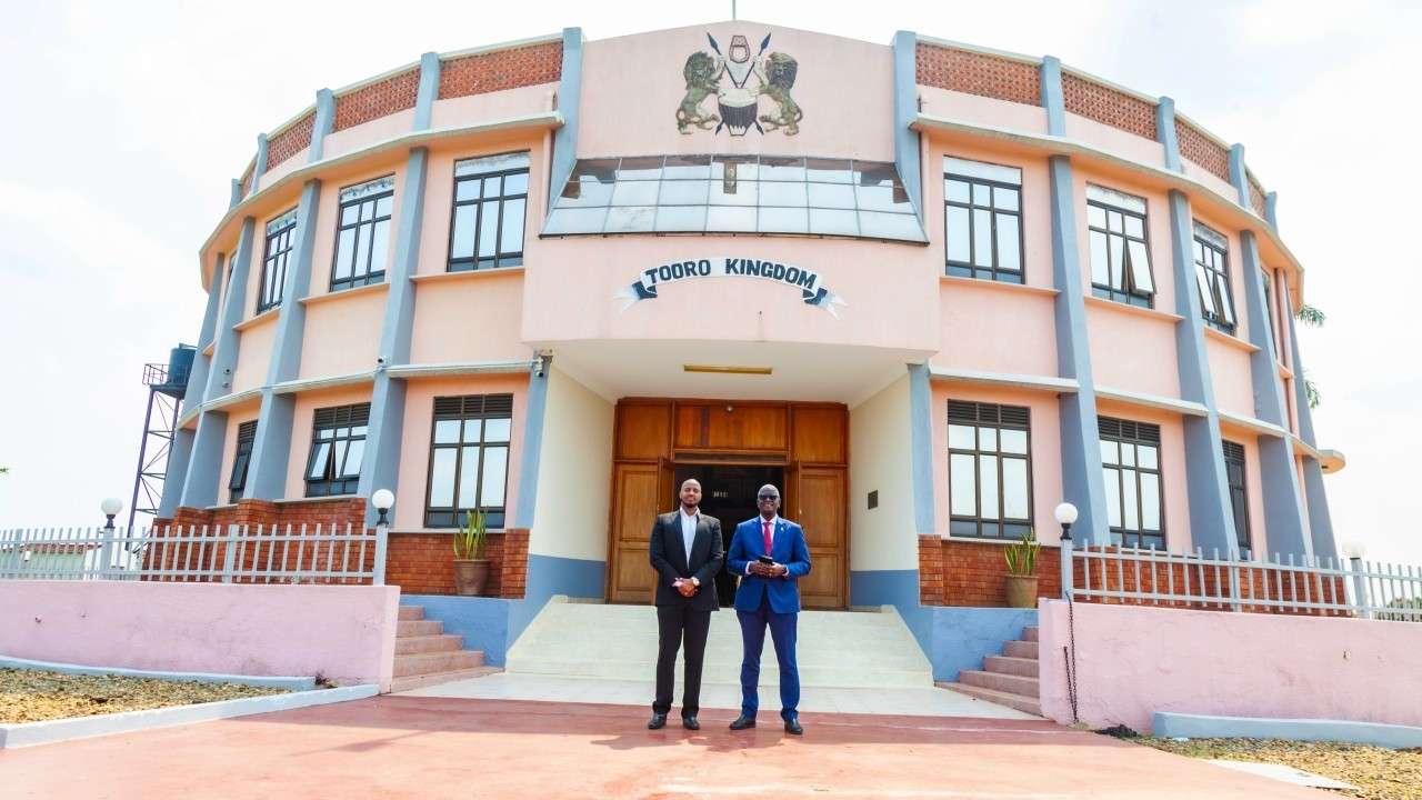 two men standing outside a big building