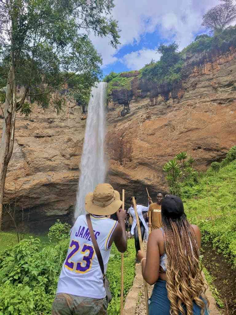 people standing next to a waterfall