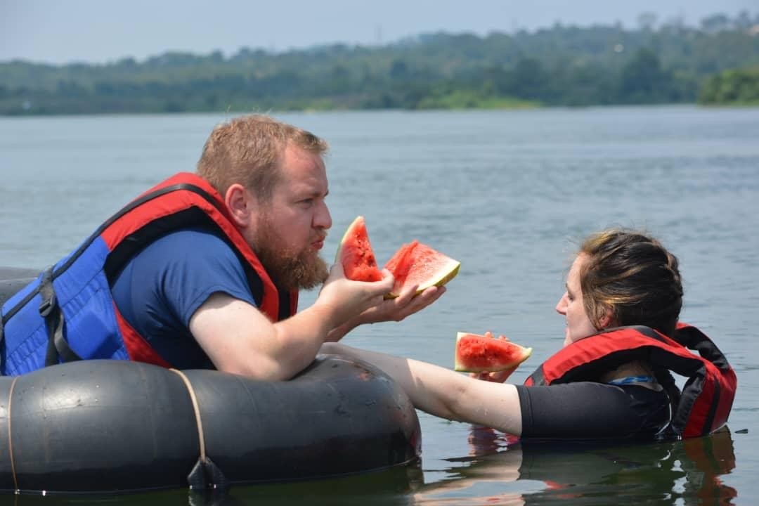 a man and a woman in a boat eating watermelone